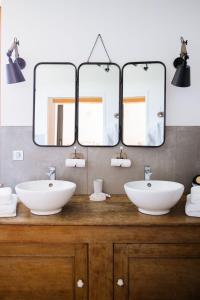 a bathroom with two sinks and two mirrors at Des sapins aux étoiles in Pierre-Percée