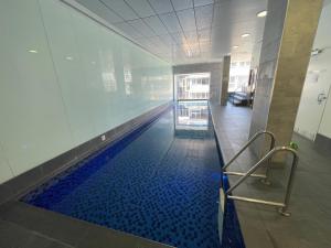 a hallway with a swimming pool in a building at Little escape at Balfours 1BR Wifi Spa Swim in Adelaide