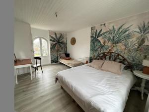 1 dormitorio con 1 cama y un mural de palmeras en Gite turon, en Saint-Sever