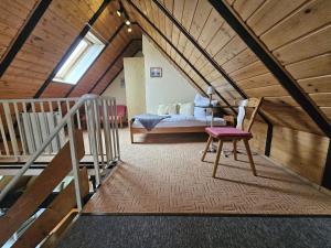 een zolderkamer met een bed en een stoel bij Reimann's Ferienwohnungen in Emden