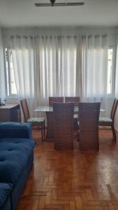 uma sala de estar com um sofá azul e uma mesa e cadeiras em Apartamento 3 quartos em Copacabana no Rio de Janeiro