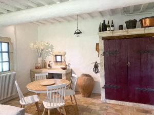 comedor con mesa y puerta roja en Mas des eaux claires Arles Camargue, en Saint-Gilles