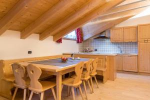 eine Küche mit einem Holztisch und Stühlen in der Unterkunft Casa Rossetti Big in Pozza di Fassa
