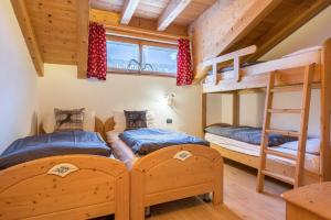 1 Schlafzimmer mit 2 Etagenbetten in einer Hütte in der Unterkunft Casa Rossetti Big in Pozza di Fassa