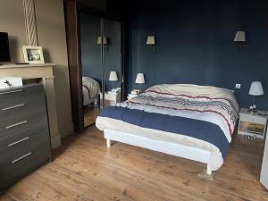 een slaapkamer met een bed, een dressoir en een spiegel bij Le gite berguois in Bergues