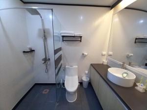 La salle de bains est pourvue de toilettes, d'un lavabo et d'une douche. dans l'établissement Green Hotel, à Ángeles