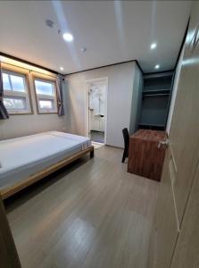 Green Hotel في انجلس: غرفة نوم بسرير وارضية خشبية