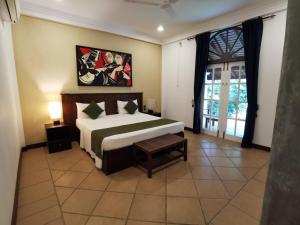 a bedroom with a bed and a large window at The Villa Green Inn in Negombo