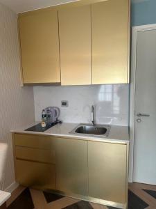 a kitchen with a sink and wooden cabinets at Espana Condo Jomtien Pool access By Aey in Jomtien Beach