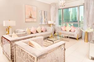 een woonkamer met witte meubels en roze kussens bij Elite Royal Apartment - Full Burj Khalifa & Fountain View - 2 Bedrooms + 1 Open Bedroom Without Partition - Magnate in Dubai