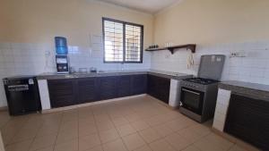 a kitchen with a stove and a sink in it at Ary Homestay Nyali - On Corral Drive in Mombasa