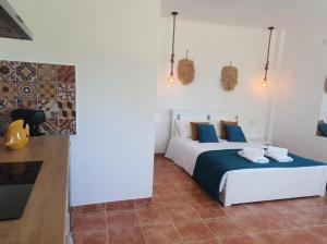 a bedroom with a bed with blue and white pillows at Monte Argil in Montargil