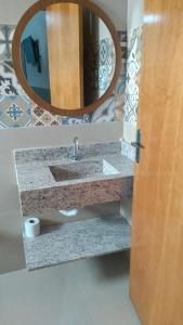 a bathroom with a sink and a mirror at Hotel Vitoria Andradina in Andradina