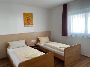 a room with two beds and a window at Pension RoBi in Harthofen