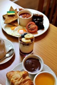 uma mesa com dois pratos de sobremesas e duas chávenas de café em Victoria Square Hotel Clifton Village em Bristol