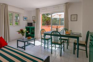 - un salon avec une table à manger et des chaises dans l'établissement Lagrange Vacances Le Domaine des Grands Pins, à Saint-Raphaël