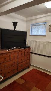 a living room with a television on a wooden dresser at Andy's Apartman in Budapest