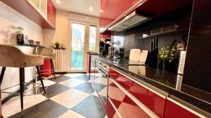 una cucina con pareti rosse e piano di lavoro di Appartement confortable entre Paris et Versailles a Ville-dʼAvray