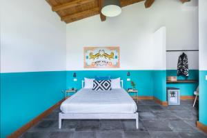 1 dormitorio con paredes azules y blancas y 1 cama en Agriturismo Braciami, en Viterbo