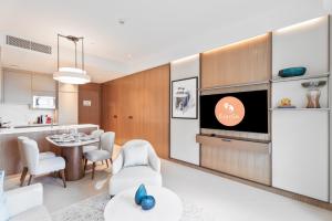 ein Wohnzimmer mit einem TV und einer Küche in der Unterkunft EasyGo - Address Opera Residences T2 -1 Bedroom in Dubai