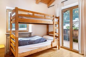 a bedroom with bunk beds and a balcony at Casa Titol Ami in Pozza di Fassa