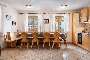 a kitchen with a dining room table and chairs at Casa Titol Ami in Pozza di Fassa