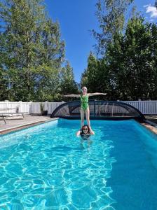 a girl standing on top of a man in a swimming pool at Villa Anna - SWEEDS Loftahammar in Loftahammar