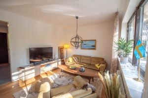a living room with couches and a tv at Villa Anna - SWEEDS Loftahammar in Loftahammar