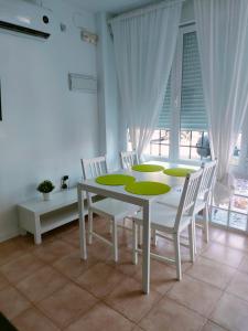 a white dining room with a white table and chairs at San Centro Airport IFEMA Wizink Metropolitano Apartments in Madrid