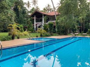 a swimming pool in front of a house at The Villa Green Inn in Negombo