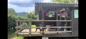 a deck with chairs and flowers on a house at les petits chalets de DUDU in La Voulte-sur-Rhône