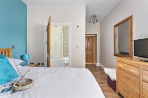 a bedroom with a bed with a tv and a mirror at Penthouse 16 At The Beach in Beesands