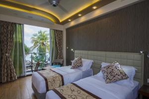 a hotel room with two beds and a balcony at Vista Beach Retreat in Hulhumale