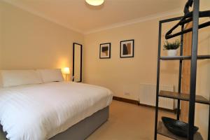 a bedroom with a white bed and a shelf at Signature - Lincoln View in Knightswood