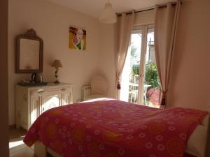 a bedroom with a bed with a red blanket and a window at A l'ombre du figuier in Lorgues