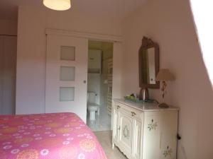 a bedroom with a bed and a vanity and a mirror at A l'ombre du figuier in Lorgues