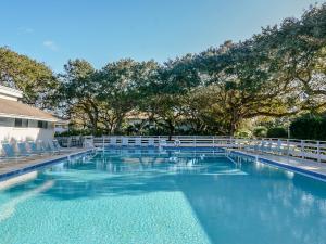 a large swimming pool with chairs and trees at SC214-Tastefully decorated 3 bedroom 2 bath condo in Edgewater