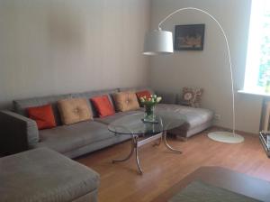 a living room with a couch and a glass table at Apartment on Riepnieku Street in Riga