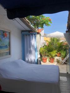 a bedroom with a bed and a view of a patio at Chez Marine Guest House in Búzios