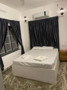 a bedroom with a bed with black curtains at The First Place Yogaresort, Odayam in Varkala