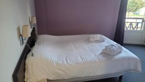 una camera da letto con un letto e asciugamani di La Truffière a Puy-lʼÉvêque