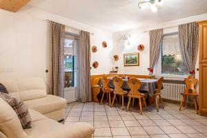 uma sala de estar com mesa e cadeiras em Casa Rossetti Grande em Pozza di Fassa