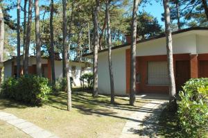 una casa con árboles delante de ella en Villette Allodola, en Lignano Sabbiadoro