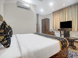 ein Hotelzimmer mit einem Bett und einem TV in der Unterkunft THE SUPERB HOTEL PVT LTD in Hyderabad