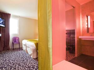 Habitación de hotel con cama y baño en ibis Styles Compiegne, en Jaux