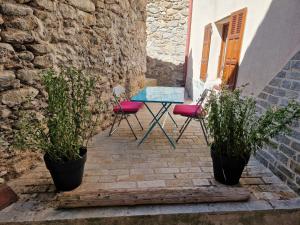 una mesa y sillas en un patio con plantas en Maison complète Ganzes Haus House 6 Peronnes La Finière Seealpen Isola Village bei Nizza Alpes -Maritimes près de Nice 70 km en Isola