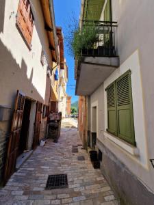 an alley with a building with green doors and a balcony at Maison complète Ganzes Haus House 6 Peronnes La Finière Seealpen Isola Village bei Nizza Alpes -Maritimes près de Nice 70 km in Isola