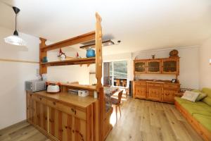 a kitchen and living room with a green couch at Casa a piè di pista in Tesero