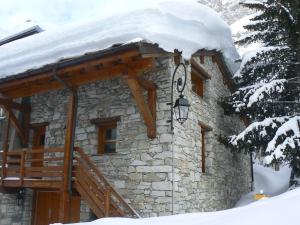 a stone building with a snow covered roof at Joli Chalet Savoyard in Val-d'Isère