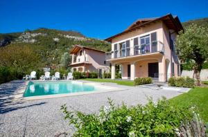 a villa with a swimming pool in front of a house at La Bella Ossuccio in Ossuccio
